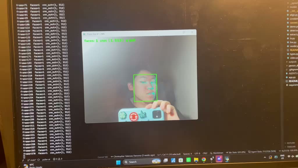 A monitor filmed off-screen running the pulse-ai project: a live webcam window with a green box locked onto a face and a mesh of cyan landmark dots across it, an overlay reading faces: 1, and a terminal column beside it streaming one line per frame, each logging the frame number and the feature vector taken from it.